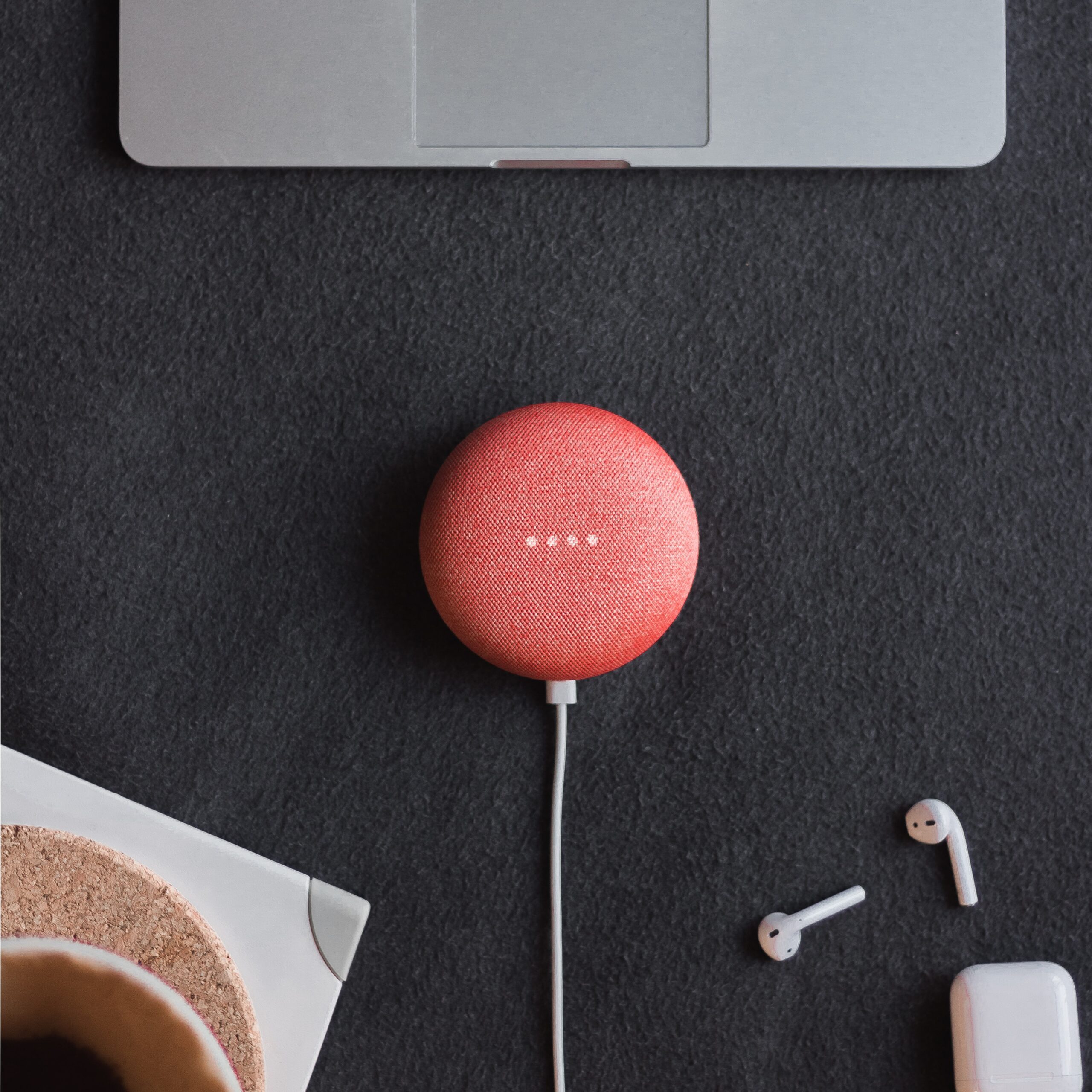 Are-Your-Smart-Home-Devices-Spying-On-You-Experts-Say-Yes-scaled.jpg flat lay photography of coral Google Home Mini on black surface beside Apple AirPods