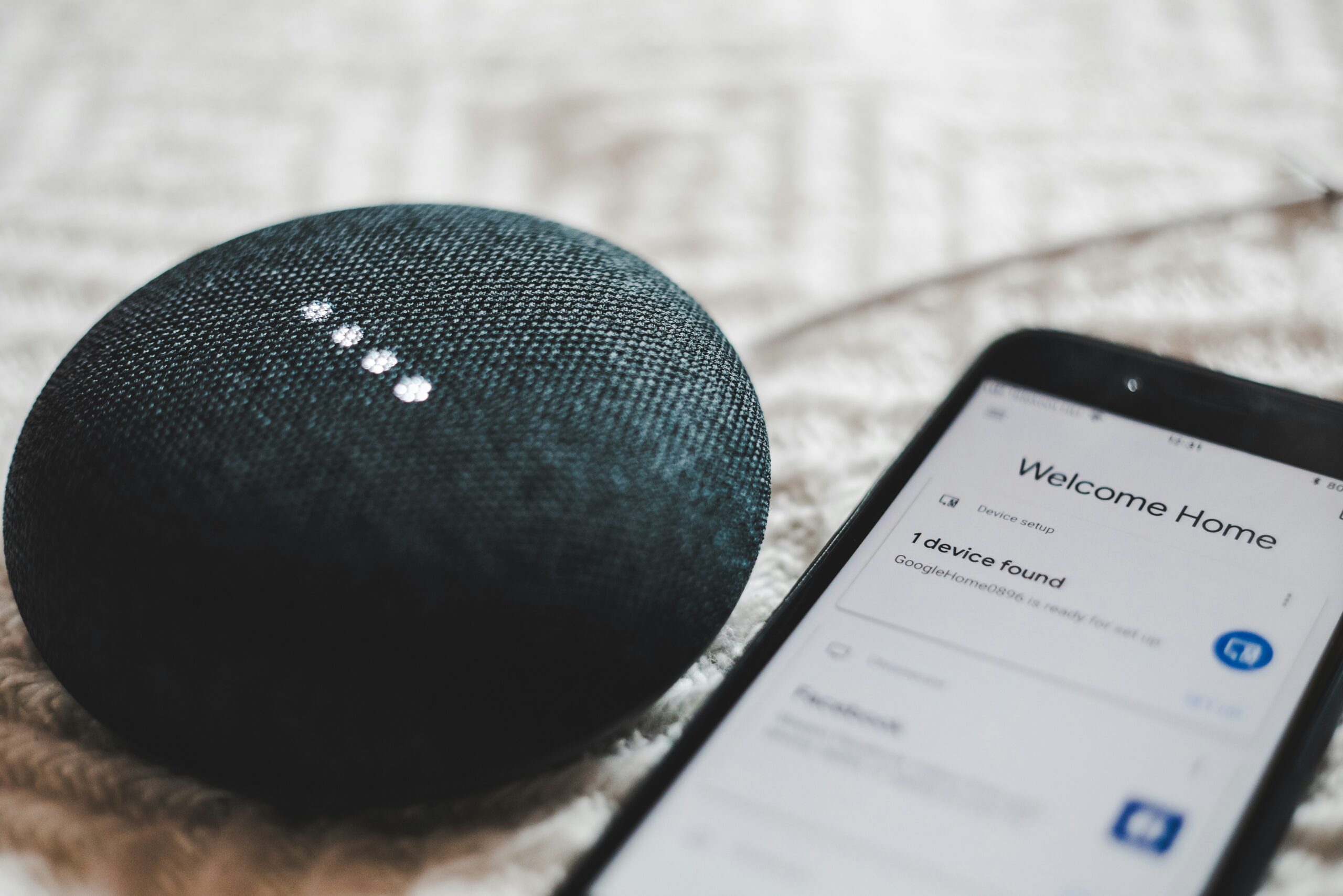 bence-boros-anapPhJFRhM-unsplash-scaled.jpg Turned-on charcoal Google Home Mini and smartphone photo